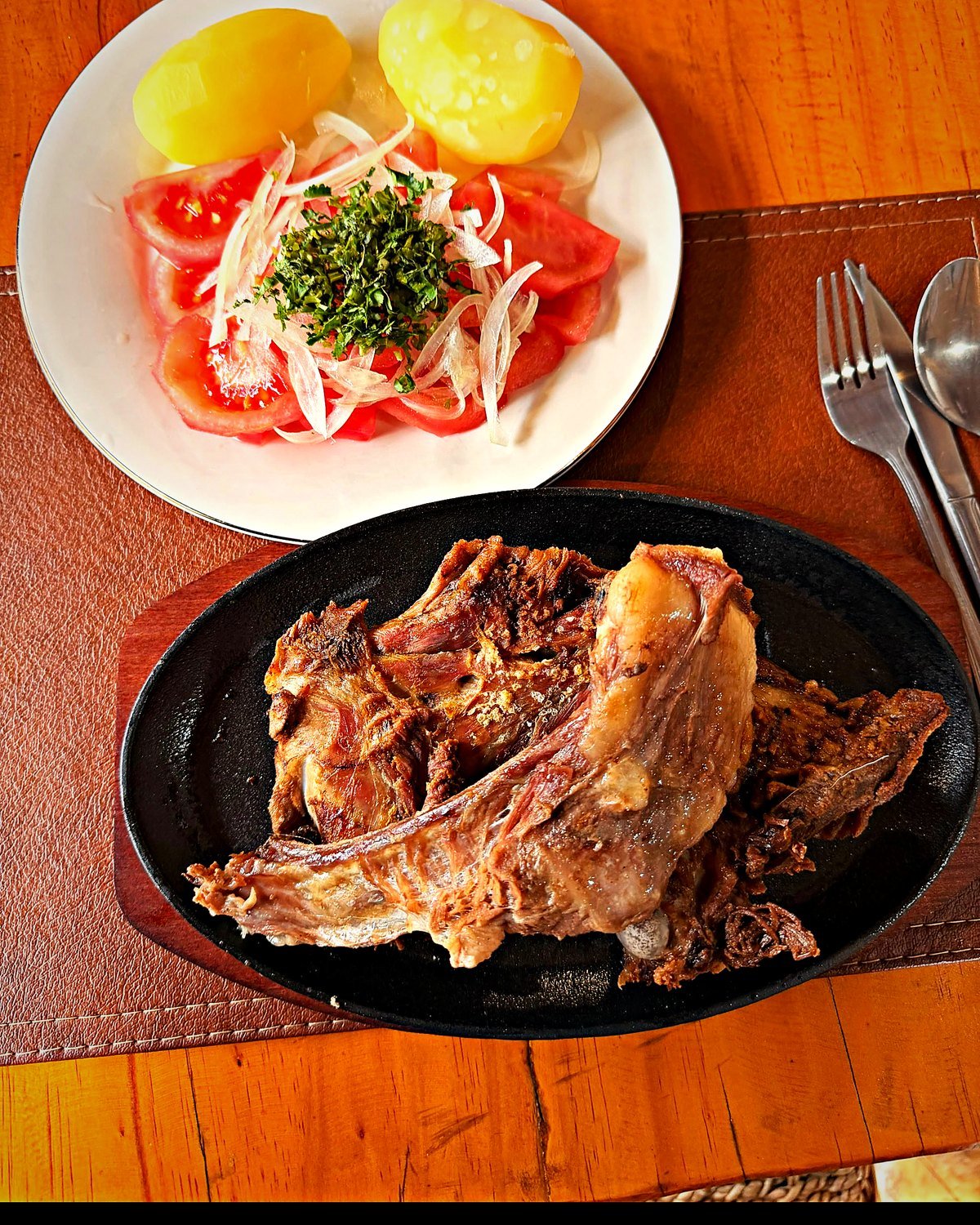 Asado de chivo con papas cocidas y ensalada chilena