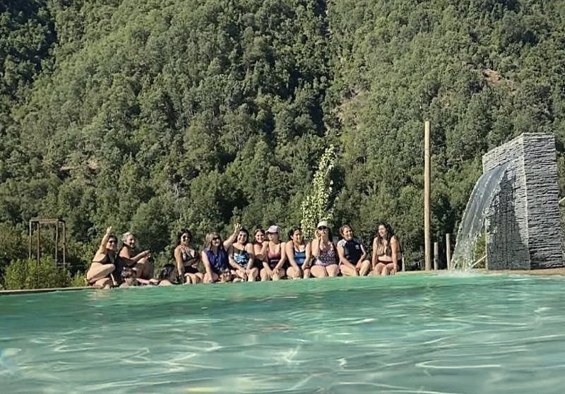 Grupo de amigas en el borde de la piscina con cascada
