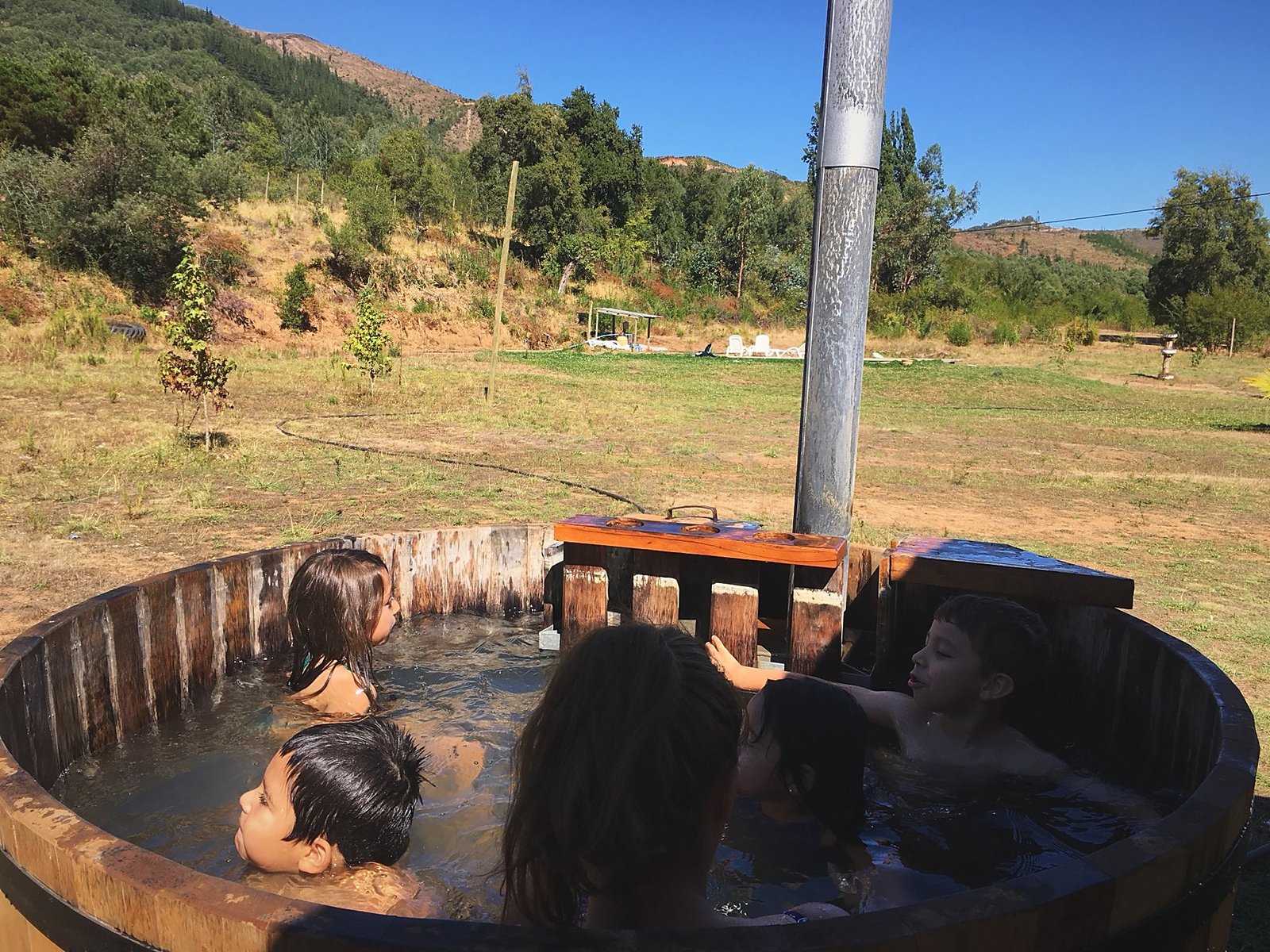 Niños en la tinaja de madera con el valle de fondo