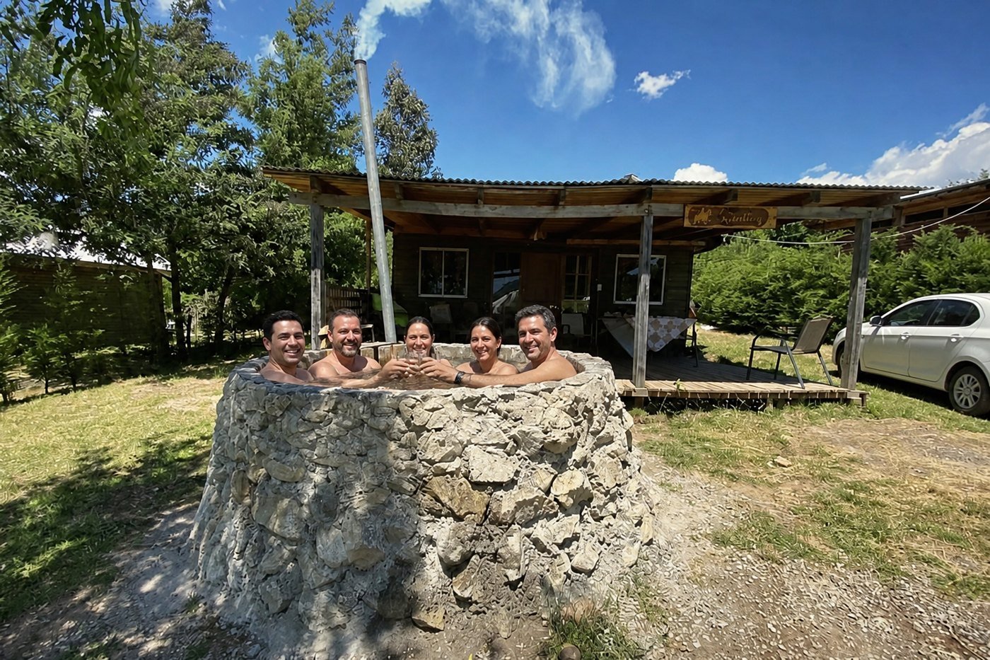 Amigos brindando en la tinaja de piedra de la cabaña Quillay