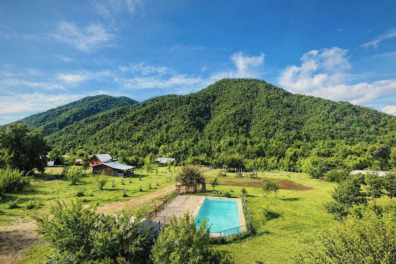 Valle de Los Hualles con la piscina y las cabañas de Manantial del Arriero